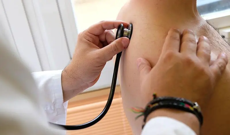  Un m&eacute;dico ausculta a un paciente. 