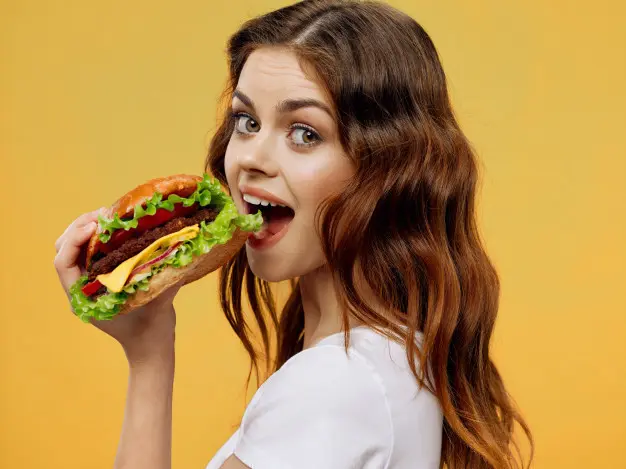 Mujer comiendo una hamburguesa