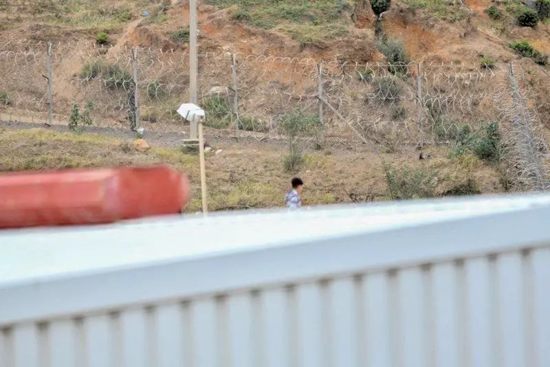  Un ni&ntilde;o camina por un tejado al tratar de escapar de la nave de primera acogida del pol&iacute;gono del Tarajal, en Ceuta (Espa&ntilde;a). - Antonio Sempere - Europa Press 