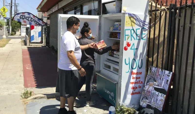  Vecinos depositando comida en una de las neveras comunitarias. 