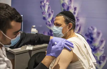  Un jud&iacute;o ortodoxo recibe su dosis de la vacuna Pfizer-BioNTech COVID-19 en un centro de vacunaci&oacute;n como parte de una campa&ntilde;a nacional. 