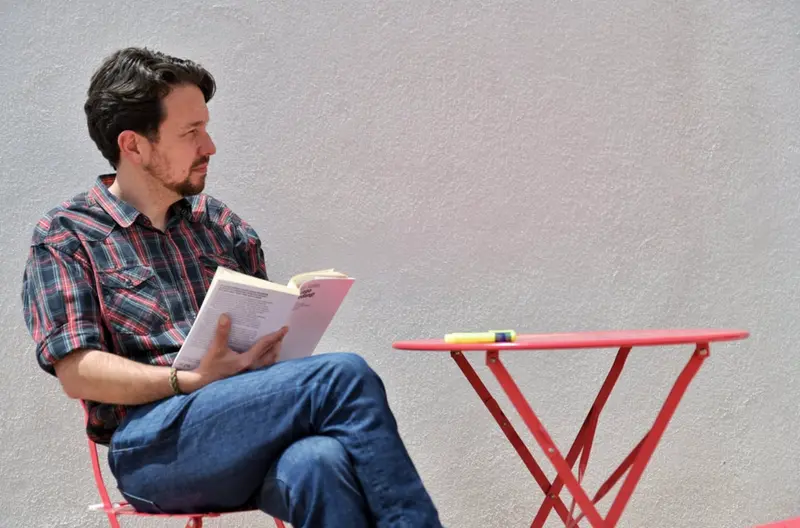  El exsecretario general de Podemos, Pablo Iglesias, lee un libro tras cortarse el pelo y dejar atr&aacute;s su ic&oacute;nica coleta. - DANI GAGO 
