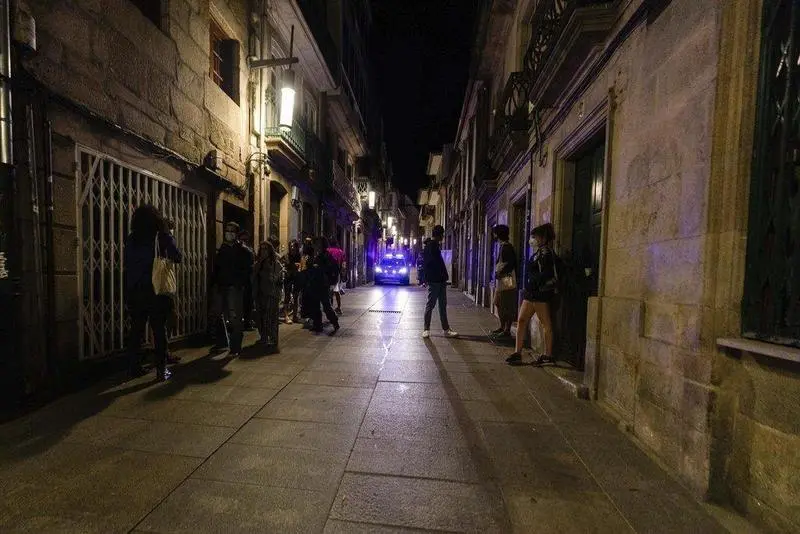  Un coche de polic&iacute;a pasa frente a varias personas en ambiente festivo, a 10 de julio de 2021, en Pontevedra, Galicia (Espa&ntilde;a) - Beatriz Ciscar - Europa Press 