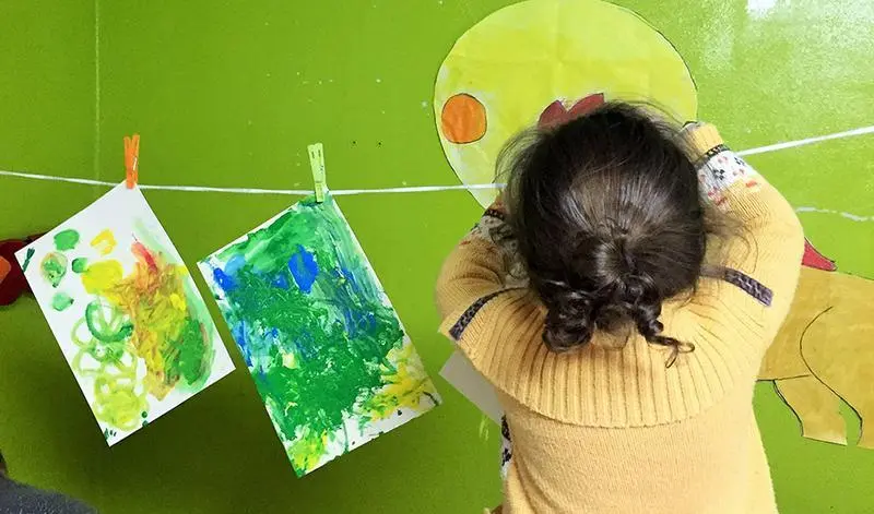  Una ni&ntilde;a cuelga sus pinturas para que se sequen en una casa de acogida para v&iacute;ctimas de violencia de g&eacute;nero. 