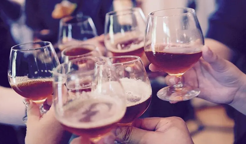  Un grupo de amigos brinda con cerveza en una terraza. 