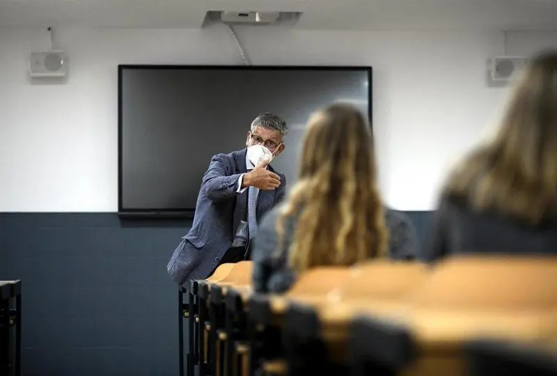  Un profesor da clase con mascarilla 
