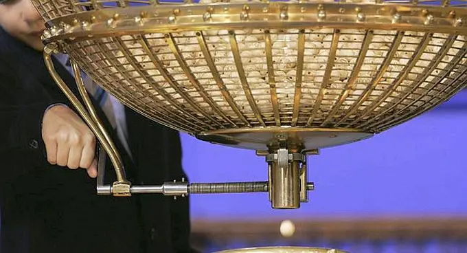 A boy from a school that was once an orphanage, lets a winning prize ball fall during the Christmas Lottery draw in Madrid, Saturday Dec. 22, 2007. Raul Barrak and Alvaro Lopez Guerrero, children from a school that was once an orphanage, had the privilege of reading out the Christmas lottery prize number which was 06381 before 11 am (1000 GMT). The complex sweepstake, held in a televised ceremony brings Spain to a standstill, with an estimated three of every four Spaniards holding tickets for what is billed as one of the world's richest lottery. The lottery shuns jackpots in favor of a share-the-wealth system in which thousands of numbers yield at least some degree of Christmas mirth, ranging from the face value of a 20-euro ticket, through a series of more lucrative but lower-level winnings all the way up to the first-prize number, called El Gordo. (AP Photo/Bernat Armangue)