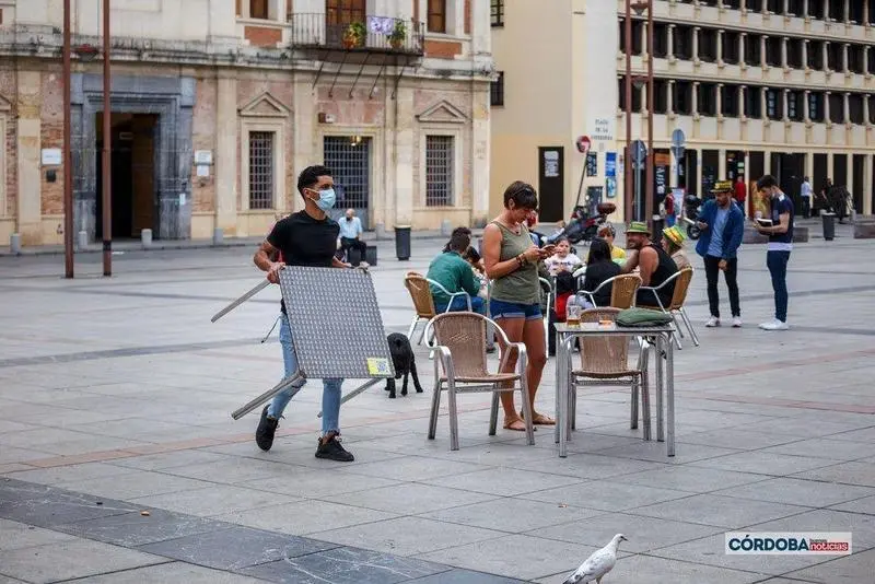 Un camarero recoge una de las terrazas en La Corredera, C&oacute;rdoba. | Jos&eacute; Le&oacute;n. 