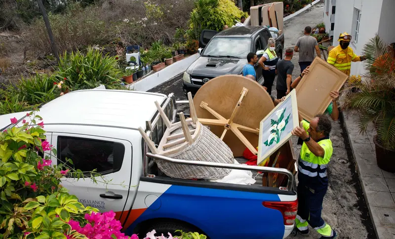 Varias personas de mantenimiento del Ayuntamiento y bomberos colaboran en recoger las pertenencias de los vecinos del n&uacute;cleo urbano de Todoque durante el desalojo de sus viviendas ante la aproximaci&oacute;n de la lava del volc&aacute;n - Kike Rinc&oacute;n - Europa Press 