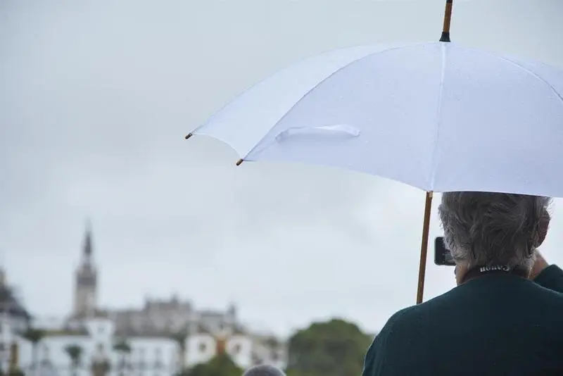 <p> Un se&ntilde;or, bajo su paraguas, toma una foto con su m&oacute;vil del r&iacute;o Guadalquivir en un d&iacute;a lluvioso del puente de Todos los Santos el 30 de octubre de 2021 en Sevilla (Andaluc&iacute;a, Espa&ntilde;a) - Joaquin Corchero - Europa Press </p>