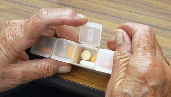 Columbia, MD--5/29/03--At Howard County's Florence Bain Senior Center, a counselling group discussion, card game, people sit alone, wheelchair, walkers, cane, pills. Group, counterclockwise around table: Jacqueline Greene, group leader, short hair, grey suit, later with walker indoors and out putting it in car trunk; Teresa Plant, dark blue top and bottom; Nysa Marrell, lavender top w. sweater, walks outside w. cane; Alice Yos, blue jacket; Dorothy Jeffery, tan sweater; Margaret Adamski, light green sweater.  Arthur Cohen in wheelchair, talks to Edward Joell in hat, then reads book and sits alone. Card game: Louise News (black shirt, sunglasses), Christel van der Berg (white shirt, glasses, put on coat for sitting alone shots; Carole Cook, red hair; Mirriam Sorrell, striped shirt. Copyright 2003 by Marty Katz 