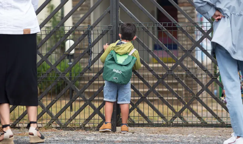 <p> Un ni&ntilde;o se asoma a las puertas de su colegio en Nadela (Lugo) - Carlos Castro - Europa Press </p>