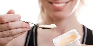 <p> Persona comiendo un yogur </p>