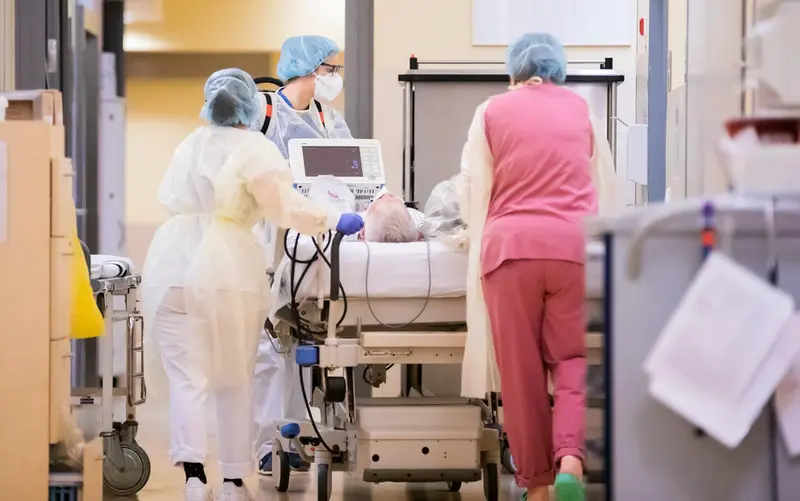 <p> 29 December 2021, Berlin: A resident (C) pushes the bedside of a Coronavirus (Covid-19) patient with intensive care nurses in the intensive care unit of the Havelhoehe Community Hospital. Photo: Christoph Soeder/dpa - Christoph Soeder/dpa </p>