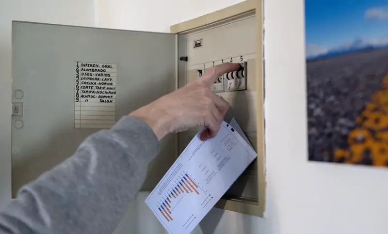 <p> Un hombre sube los plomos de la luz con una factura de luz en la mano, a 3 de enero de 2022, en Madrid - Alberto Ortega - Europa Press </p>