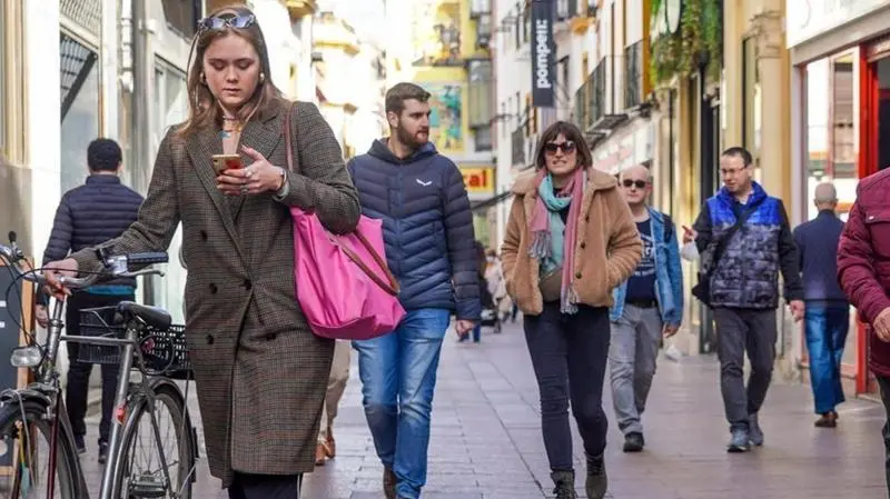 <p> Una mujer en bicicleta y otros ciudadanos sin mascarillas y otro con ella por la calle Sierpes, , en el primer d&iacute;a sin la obligaci&oacute;n de llevar mascarillas por las calle a 10 de febrero del 2022 en Sevilla (Andaluc&iacute;a) - Eduardo Briones - Europa Press </p>