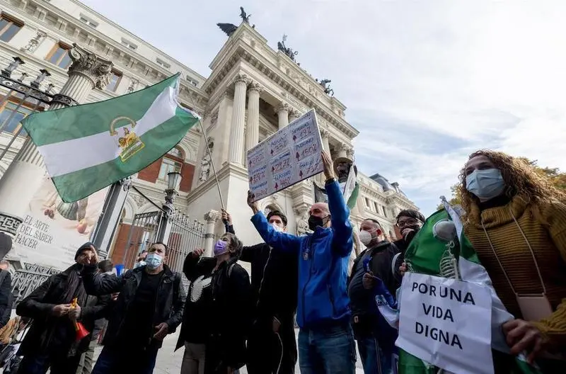 <p> Un grupo de personas con la bandera de Andaluc&iacute;a participa en una concentraci&oacute;n de agricultores y exportadores de naranjas, frente al Ministerio de Agricultura </p>