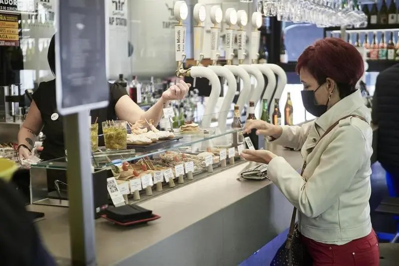 <p> Una mujer paga su consumici&oacute;n en el interior de un bar - Eduardo Sanz - Europa Press - Archivo </p>