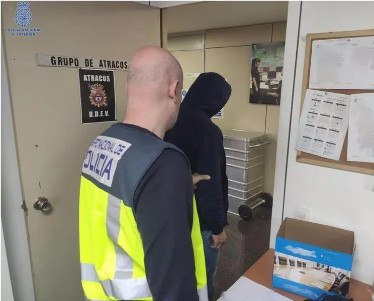 <p> Uno de los arrestados, conducido por uno de los agentes </p>