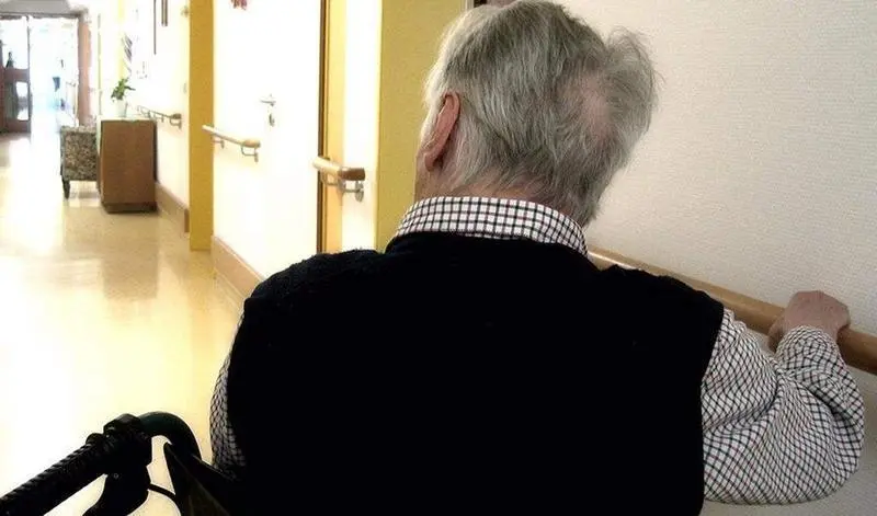 <p> Una persona en silla de ruedas se desplaza por los pasillos de una residencia de mayores. EUROPA PRESS </p>