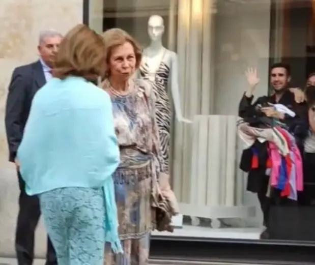 <p> El dependiente de la tienda saluda a la reina en una captura del v&iacute;deo </p>