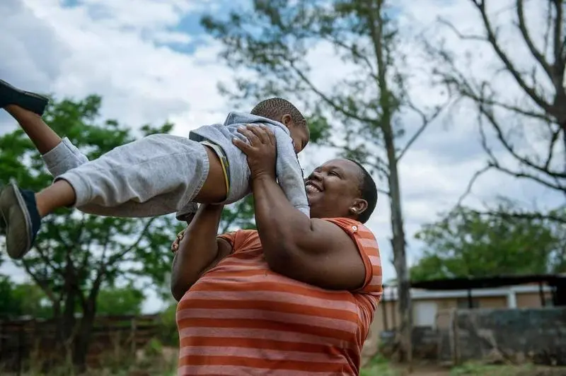 <p> Dora,&nbsp;una avicultora del pueblo de Serowe que es seropositiva, junto a su hijo. </p>