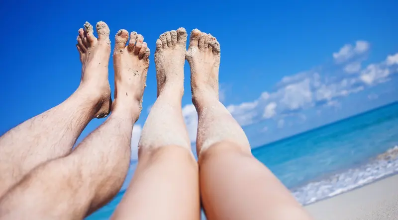 <p> Archivo - Piernas de una pareja en la playa. - KRISCOLE / ISTOCK - Archivo </p>