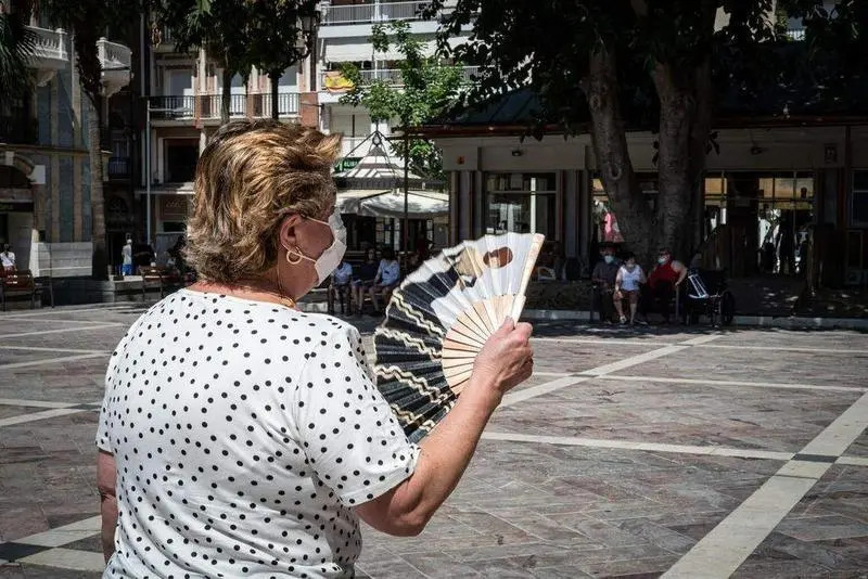 <p> Se&ntilde;ora con abanico y mascarilla. ARCHIVO </p>