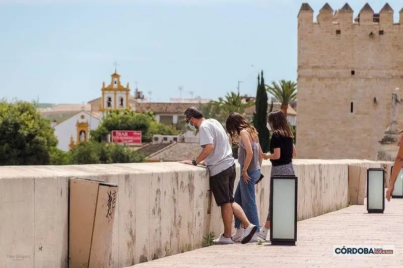<p> Personas asom&aacute;ndose al r&iacute;o en el Puente Romano / Pilar Gázquez. </p>