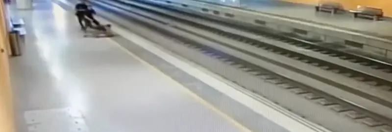 <p> Dos agentes de la Polic&iacute;a Nacional interceptando a una mujer que intent&oacute; arrojarse a las v&iacute;as </p>