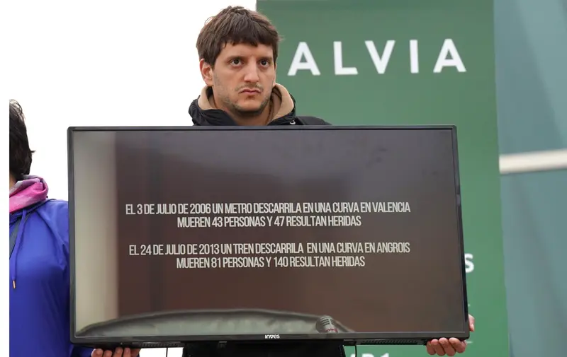 <p> Un familiar de una v&iacute;ctima en el accidente de Alvia sujeta una pantalla de televisi&oacute;n con una imagen del exdirector de Seguridad en la circulaci&oacute;n de Adif, Andr&eacute;s Cortabitarte, mientras declara en el juicio por el accidente del Alvia, en la Cidade de la C - &Aacute;lvaro Ballesteros - Europa Press </p>