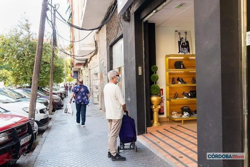 <p> Hombre delante de una tienda de zapatos en Ciudad Jardín / Pilar Gázquez. </p>