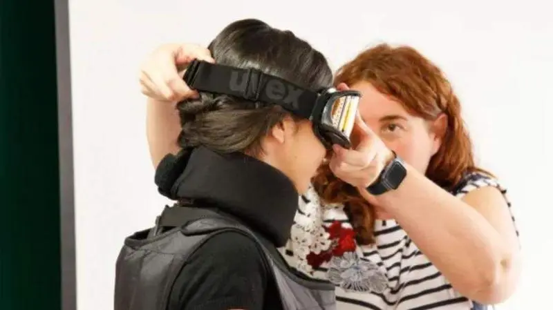 <p> Una estudiante poni&eacute;ndose parte del traje simulador </p>