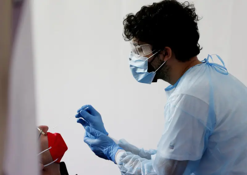  28 December 2021, Italy, Rome: A health worker collects a nasal swab sample from a woman to test for the Coronavirus (Covid-19) in a pharmacy. Photo: Cecilia Fabiano/LaPresse via ZUMA Press/dpa - Cecilia Fabiano/LaPresse via ZUM / DPA 