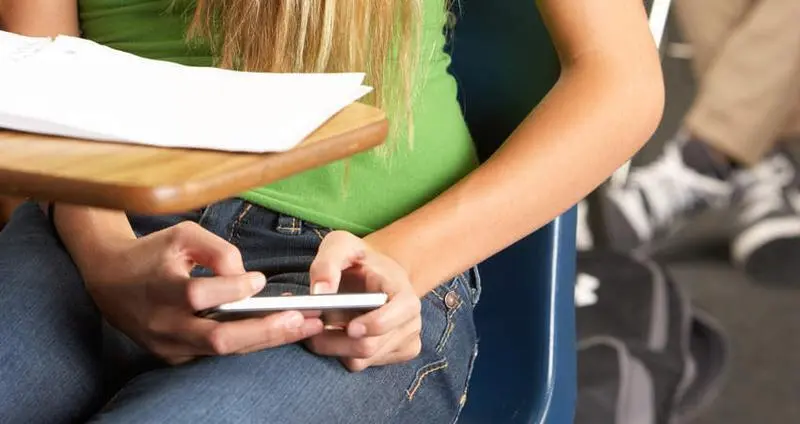  Female Pupil Sending Text Message In Classroom 