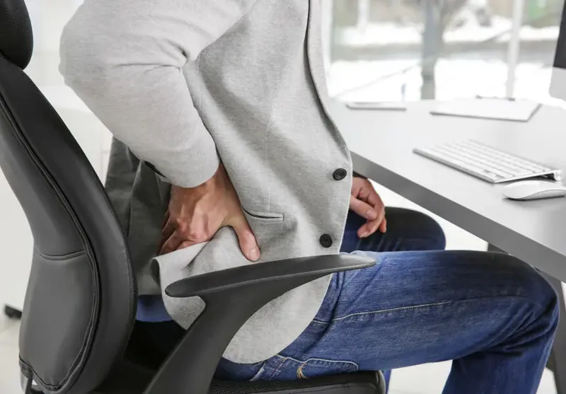  Persona sentada mucho tiempo en la oficina 