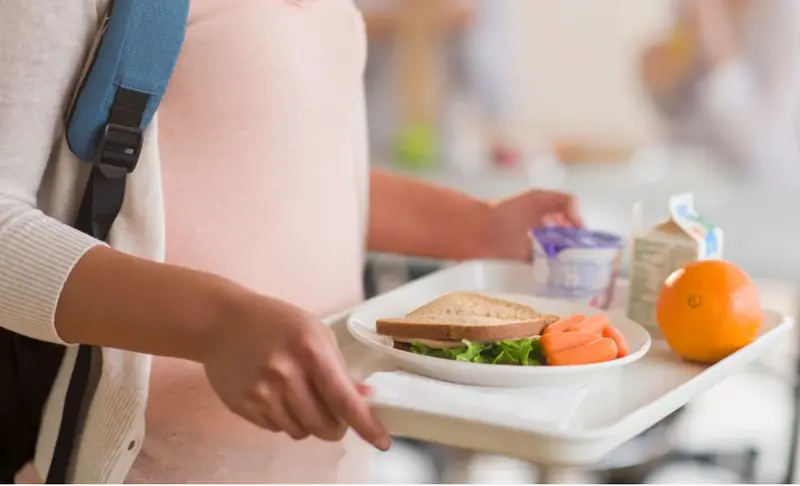  Estudiante estadounidense con una bandeja con su almuerzo 