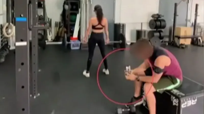  Hombre haciendo fotos sin permiso a una mujer en el gimnasio 