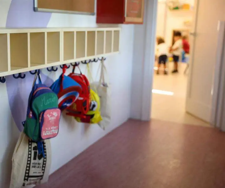  Varias mochilas en una percha de un aula de 0 a 3 a&ntilde;os de un colegio 