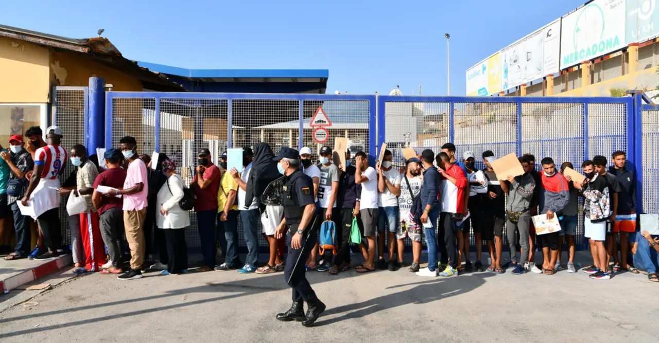  Archivo - Un agente de Polic&iacute;a supervisa a cientos de personas que guardan cola en la oficina para tramitar los asilos situada en Ceuta. - Antonio Sempere - Europa Press - Archivo 