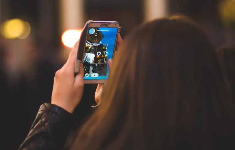  Archivo - Una chica mira la pantalla de su tel&eacute;fono m&oacute;vil. - AYUNTAMIENTO DE ARROYO DE LA LUZ - Archivo 