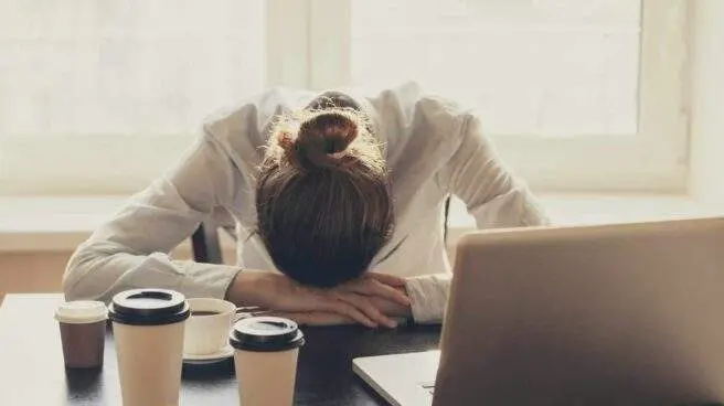  Trabajadora agobiada frente al port&aacute;til 