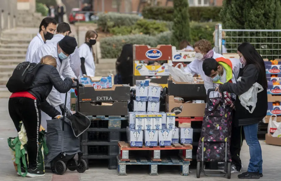 Varias personas recogen comida de la Fundaci&oacute;n Madrina. 