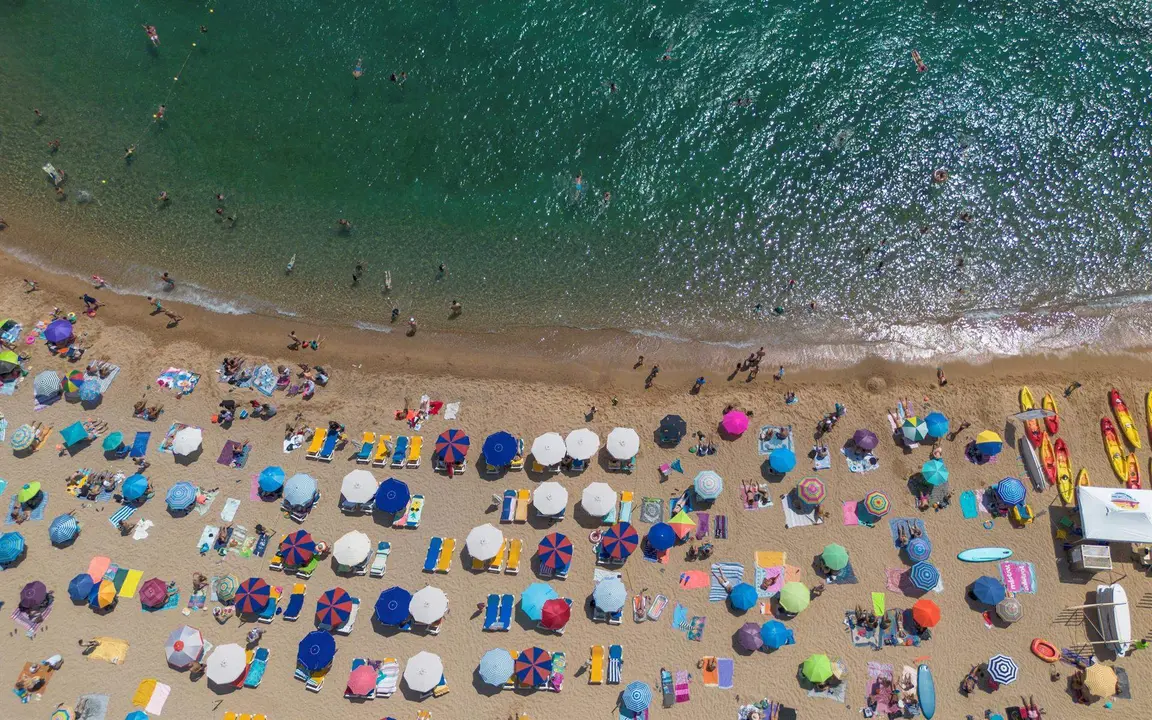  Numerosas personas disfrutan de un d&iacute;a de playa en la Costa Brava, en Tossa de Mar, Girona, Catalu&ntilde;a 