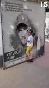  Momento del v&iacute;deo en el que un ni&ntilde;o abraza la foto de su padre colocada en las calles de Ucrania - TELECINCO 