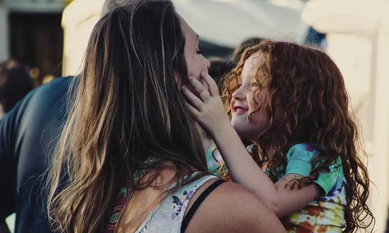  Una mujer abraza a una ni&ntilde;a. 