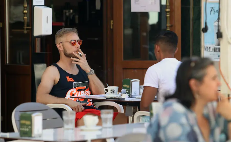  Personas fumando en terraza. EP 