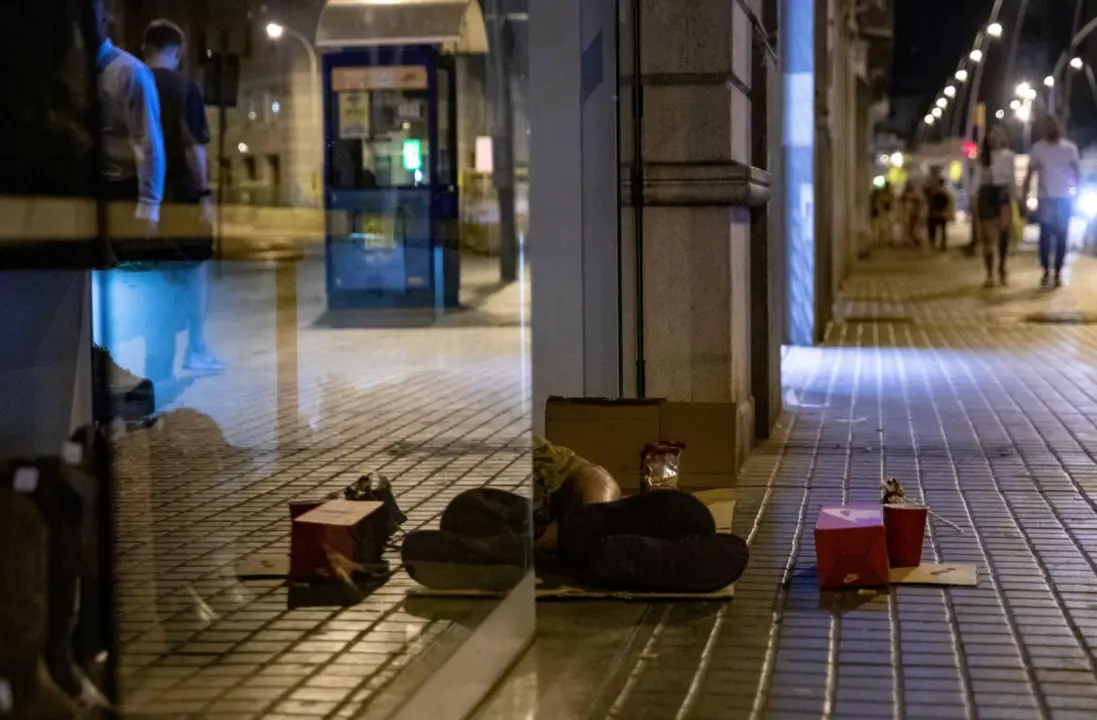  Archivo - Una persona duerme a las puertas de una zapater&iacute;a. - Kike 