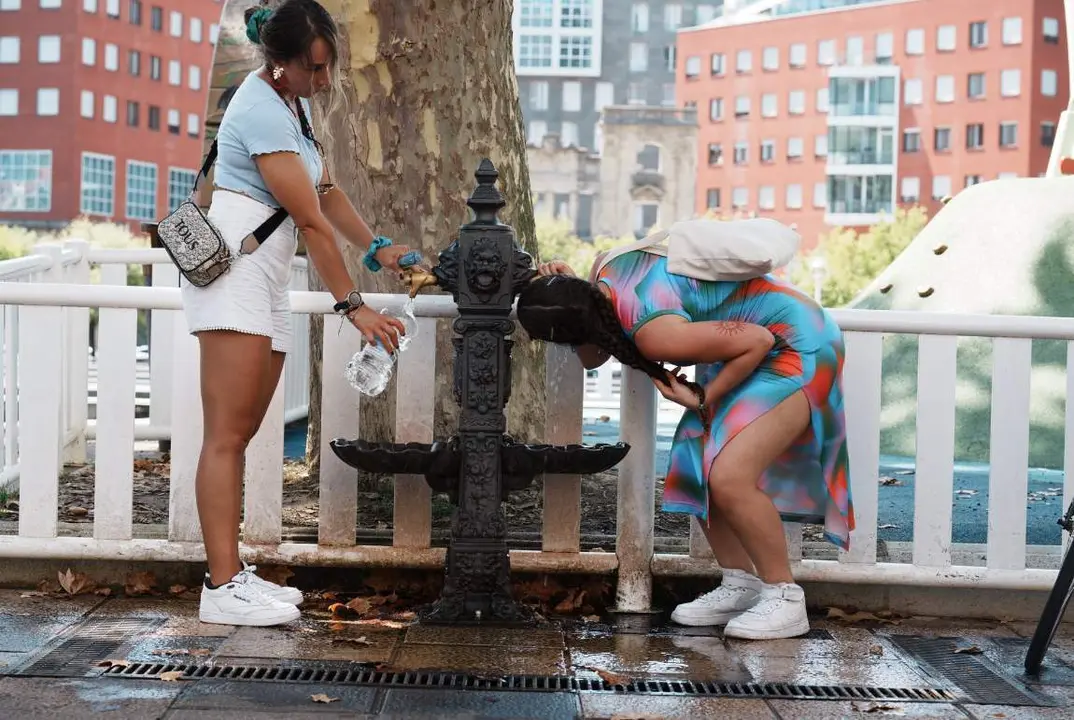  Archivo - Una mujer bebe agua de una fuente durante la cuarta ola de calor del verano, a 23 de agosto de 2023, en Bilbao, Vizcaya, Pa&iacute;s Vasco (Espa&ntilde;a). - H.Bilbao - Europa Press - Archivo 