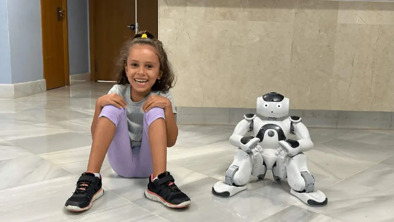  Una ni&ntilde;a junto al robot terap&eacute;uta 